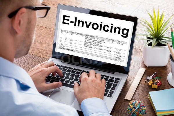 Businessman Preparing E-Invoicing Bill On Laptop At Desk Stock photo © AndreyPopov