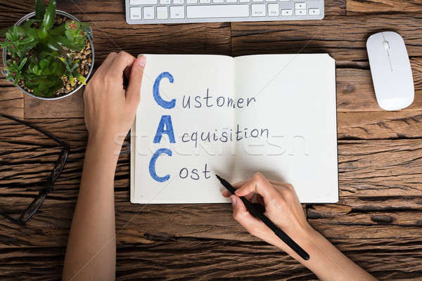 Businessperson Writing Customer Acquisition Cost Concept Stock photo © AndreyPopov