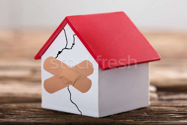 House Model With Crossed Band Aid Stock photo © AndreyPopov