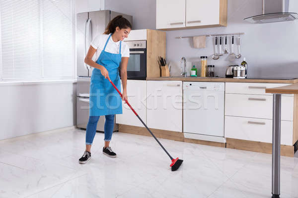 Hizmetçi temizlik zemin süpürge gülen genç Stok fotoğraf © AndreyPopov