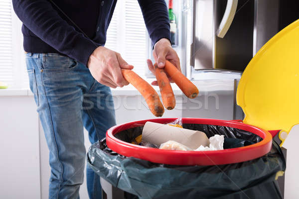 Person Throwing Carrot In Dustbin Stock photo © AndreyPopov