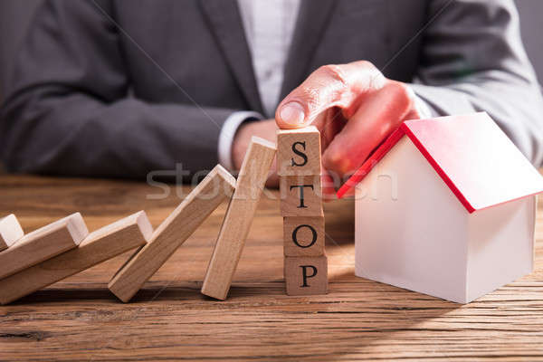 Businessperson Stopping Wooden Dominos From Falling Stock photo © AndreyPopov