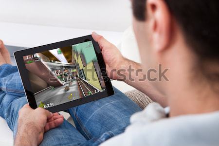Man Playing Game On Tablet Pc Stock photo © AndreyPopov