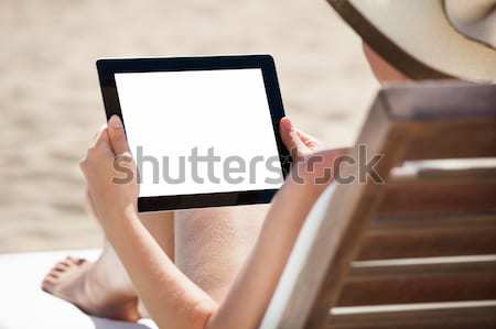 Woman Using Digital Tablet On Beach Chair Stock photo © AndreyPopov
