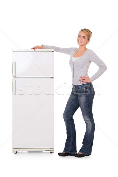 Woman Leaning On Refrigerator Over White Background Stock photo © AndreyPopov