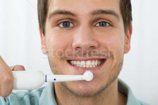 Férfi fogmosás elektromos fogkefe közelkép fiatalember Stock fotó © AndreyPopov