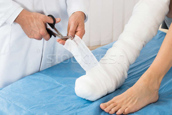 Doctor Bandaging Leg Of Patient Stock photo © AndreyPopov