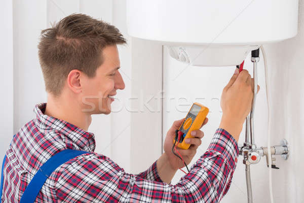 Male Plumber Examining Electric Boiler Stock photo © AndreyPopov