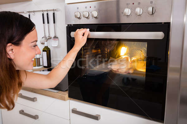 Woman Roasting Chicken Meat In Oven Stock photo © AndreyPopov