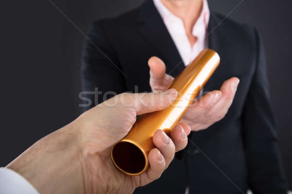 Businessman Passing A Golden Relay Baton Stock photo © AndreyPopov