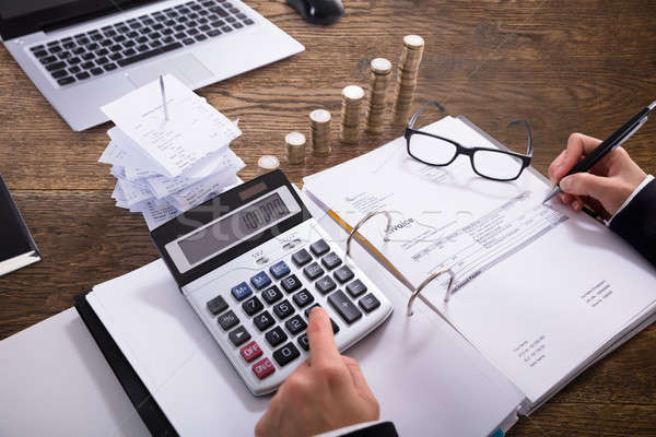 Close-up Of A Businessperson Calculating Invoice Stock photo © AndreyPopov