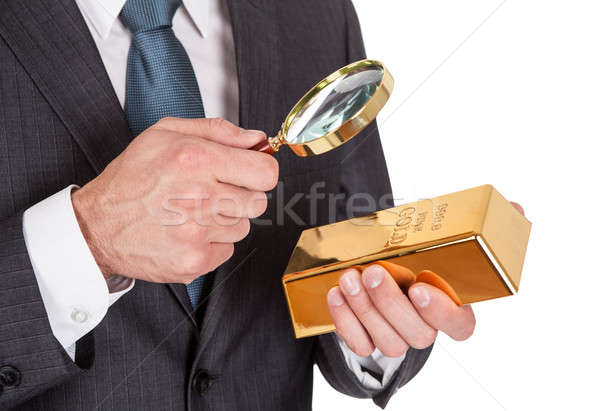 Stock photo: Businessman looking at gold bar through loupe