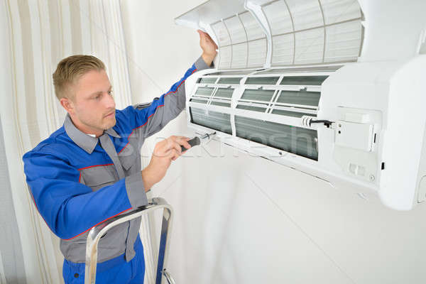 Stock photo: Repairer Repairing Air Conditioner