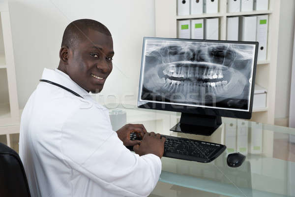 Dentist With Teeth X-ray On Computer Stock photo © AndreyPopov