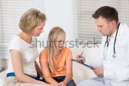 Lekarza ciśnienie krwi dziewczyna kobiet posiedzenia bed Zdjęcia stock © AndreyPopov