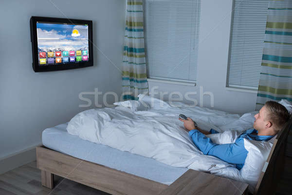 男子 看電視 臥室 年輕人 床 因特網 商業照片 © AndreyPopov