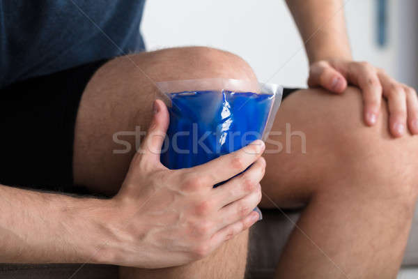 Person Sitting And Applying Ice Gel Pack On Knee Stock photo © AndreyPopov