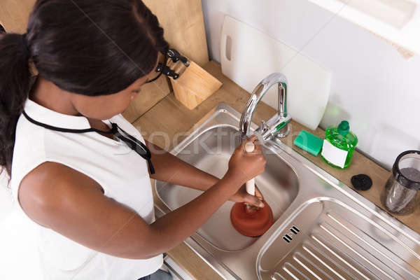 Closeup Of Man Using Plunger In Kitchen Sink Stock Photo, Picture and  Royalty Free Image. Image 23490896.