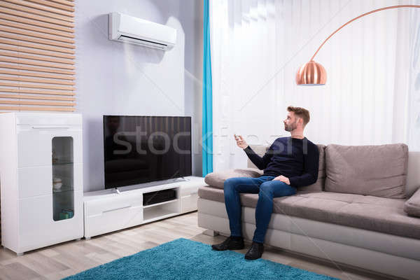 [[stock_photo]]: Jeune · homme · climatiseur · maison · séance · canapé · maison