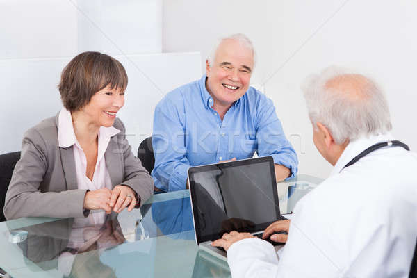 Stock photo: Happy Couple Discussing With Male Doctor