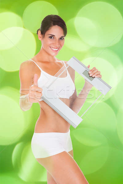 Slim Woman Gesturing Thumbsup While Holding Glass Weight Scale Stock photo © AndreyPopov