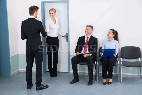 Businesswoman Shaking Hands With Man In Front Of People Stock photo © AndreyPopov