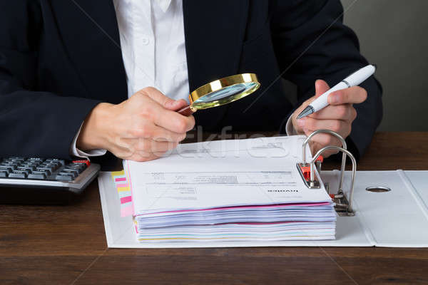 Businesswoman Scrutinizing Bills With Magnifying Glass Stock photo © AndreyPopov