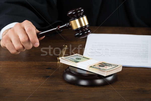 Corrupt Judge Hitting Dollar Bundle On Gavel At Desk Stock photo © AndreyPopov