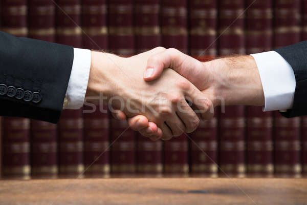 Judge And Client Shaking Hands Against Books Stock photo © AndreyPopov