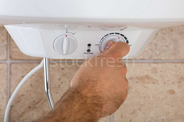 Man's Hands Turning The Knob Of Electric Boiler Stock photo © AndreyPopov