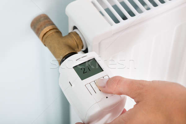 Person Adjusting Temperature On Thermostat Stock photo © AndreyPopov