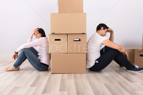 Upset Couple Sitting Back To Back Behind The Boxes Stock photo © AndreyPopov