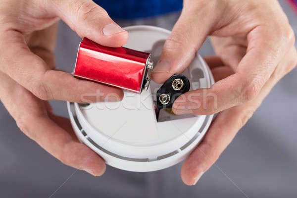 Stock photo: Person's Hand Inserting Battery In Smoke Detector