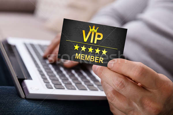 Person Using Laptop Holding Vip Member Card Stock photo © AndreyPopov