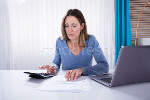 Woman Calculating Invoice With Calculator Stock photo © AndreyPopov