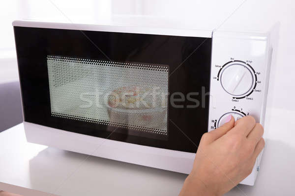 Vrouw magnetronoven oven hand Stockfoto © AndreyPopov