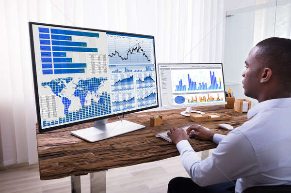 Businessman Analyzing Graphs On Computers Stock photo © AndreyPopov