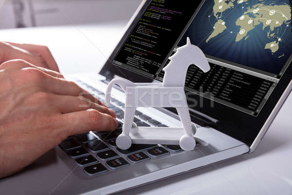 Hacker Hacking Global Network With Trojan Horse Icon On Laptop Stock photo © AndreyPopov