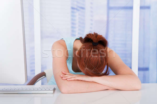 Tired Businesswoman Sleeping At Computer Desk Stock photo © AndreyPopov