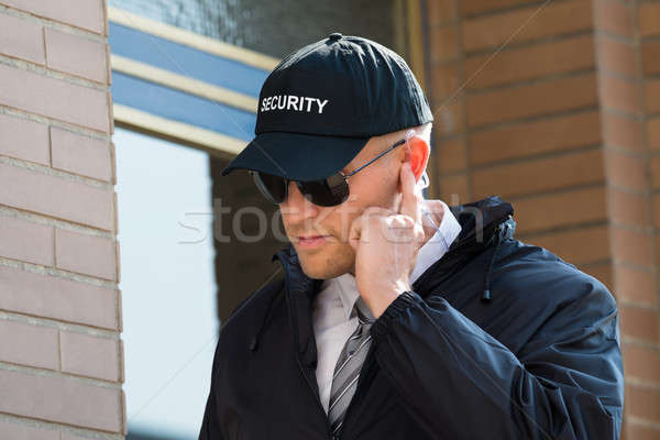 Fiatal biztonsági őr áll bejárat közelkép hallgat Stock fotó © AndreyPopov