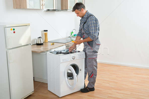 Technicien machine à laver numérique homme cuisine [[stock_photo]] © AndreyPopov