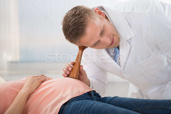 Médico escuchar ritmo cardíaco feto jóvenes estetoscopio Foto stock © AndreyPopov