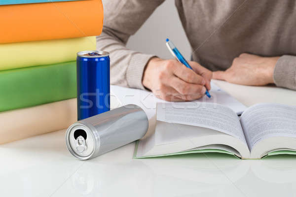 Male Student Writing In Book At Table Stock photo © AndreyPopov