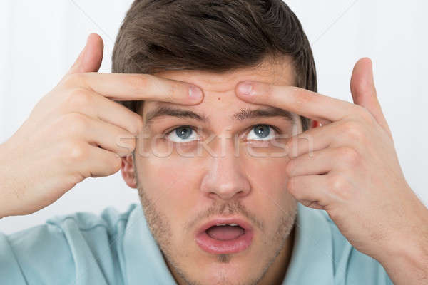 Man Looking At Pimple On Forehead Stock photo © AndreyPopov