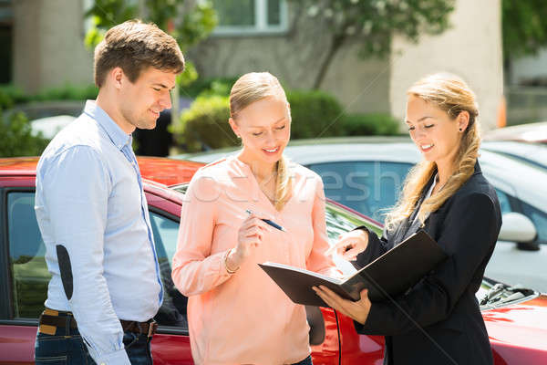 Saleswoman Explaining Contract Paper To Couple Stock photo © AndreyPopov