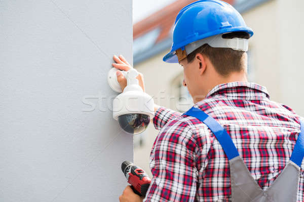 Young Male Technician Installing Camera On Wall Stock photo © AndreyPopov