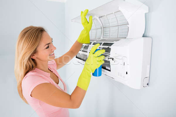 Happy Woman Cleaning The Air Conditioner Stock photo © AndreyPopov