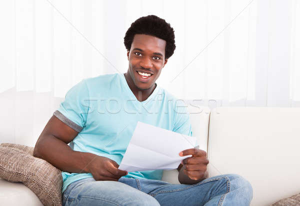 Happy Young Man Looking At Paper Stock photo © AndreyPopov
