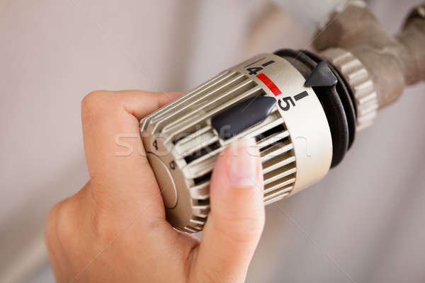 Stock photo: Woman Adjusting The Thermostat