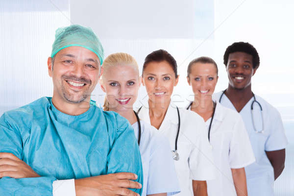 Happy Doctor In Surgical Gown With His Coworkers Stock photo © AndreyPopov